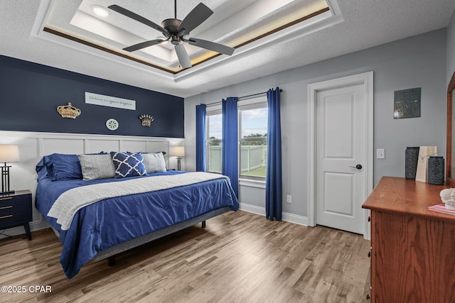 4724 Bylsma Cir, Panama City, FL 32404 - bedroom featuring a textured ceiling, wood finished floors, a raised ceiling, baseboards, and ceiling fan