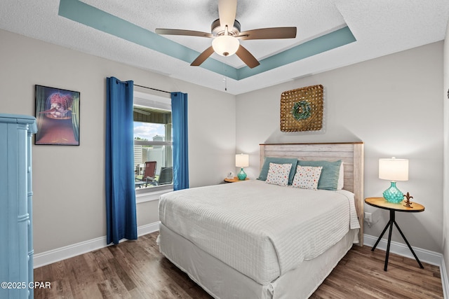 4724 Bylsma Cir, Panama City, FL 32404 - bedroom with a tray ceiling, wood finished floors, baseboards, and a textured ceiling