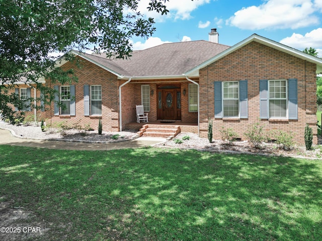 16532 SW Mimosa St, Blountstown, FL 32424 - view of front of home with brick siding, a front lawn, a chimney, a shingled roof, and a porch