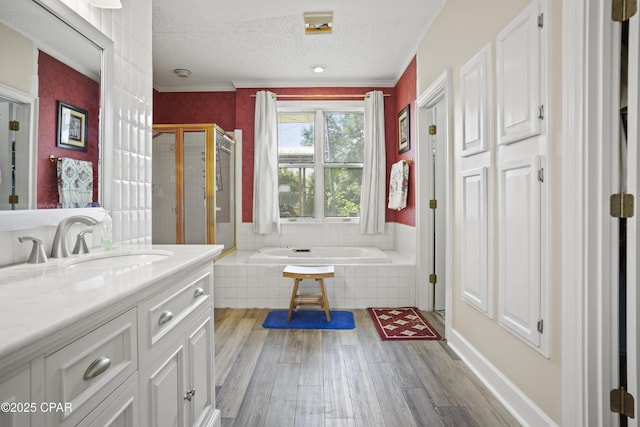 16532 SW Mimosa St, Blountstown, FL 32424 - full bath featuring wood finished floors, a garden tub, a shower stall, a textured ceiling, and vanity