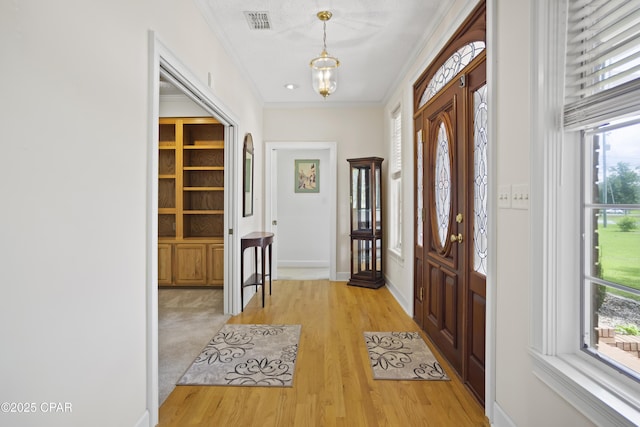 16532 SW Mimosa St, Blountstown, FL 32424 - foyer with light wood-type flooring, crown molding, baseboards, and a chandelier