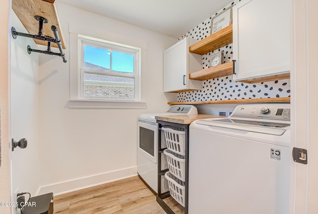 3917 Sandpine Way, Panama City, FL 32404 - washroom featuring washer and clothes dryer, cabinet space, light wood finished floors, and baseboards