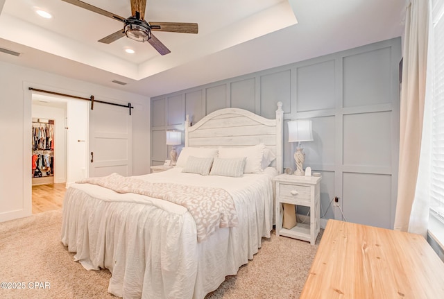 3917 Sandpine Way, Panama City, FL 32404 - bedroom featuring a decorative wall, a barn door, a tray ceiling, recessed lighting, and ceiling fan