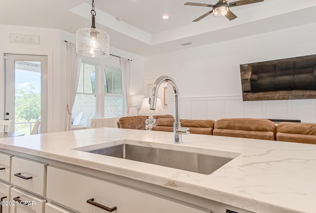 3917 Sandpine Way, Panama City, FL 32404 - kitchen with a sink, open floor plan, white cabinetry, light stone countertops, and decorative light fixtures