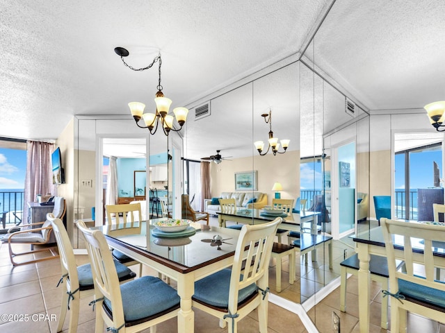 6505 Thomas Dr Unit 1009B, Panama City Beach, FL 32408 - dining space with a chandelier, a textured ceiling, healthy amount of natural light, a ceiling fan, and expansive windows