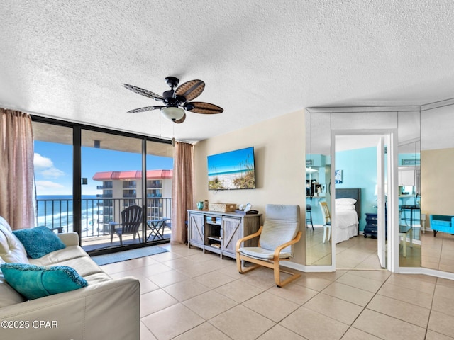 6505 Thomas Dr Unit 1009B, Panama City Beach, FL 32408 - tiled living room featuring a wall of windows, ceiling fan, and a textured ceiling