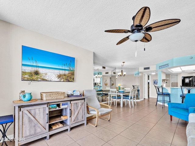6505 Thomas Dr Unit 1009B, Panama City Beach, FL 32408 - tiled living room with a textured ceiling, a ceiling fan, and a chandelier