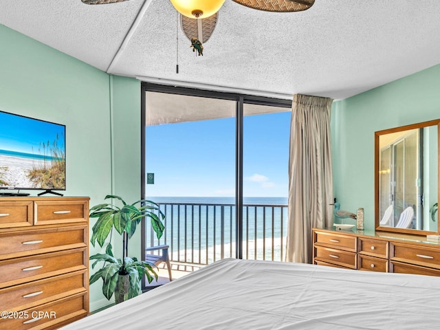 6505 Thomas Dr Unit 1009B, Panama City Beach, FL 32408 - bedroom featuring view of water and beach, floor to ceiling windows, and a textured ceiling