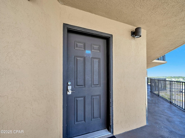 6505 Thomas Dr Unit 1009B, Panama City Beach, FL 32408 - view of exterior entry featuring stucco siding and a balcony