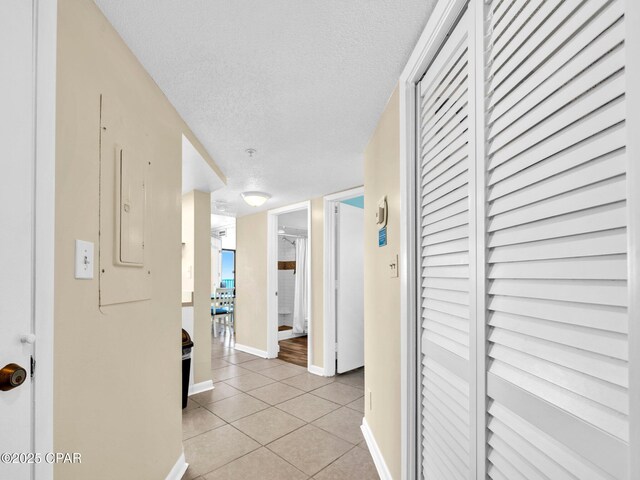 6505 Thomas Dr Unit 1009B, Panama City Beach, FL 32408 - hall featuring light tile patterned flooring, baseboards, and a textured ceiling