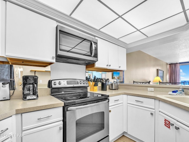 6505 Thomas Dr Unit 1009B, Panama City Beach, FL 32408 - kitchen with stainless steel appliances, white cabinets, and light countertops