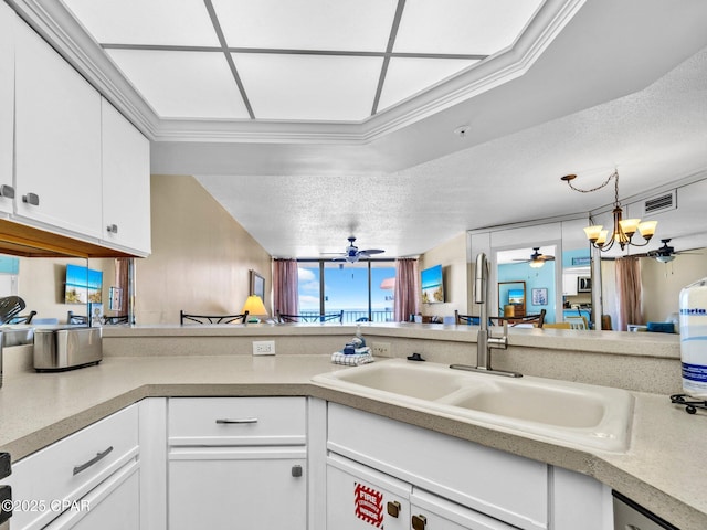 6505 Thomas Dr Unit 1009B, Panama City Beach, FL 32408 - kitchen featuring a sink, ceiling fan, white cabinetry, light countertops, and a textured ceiling