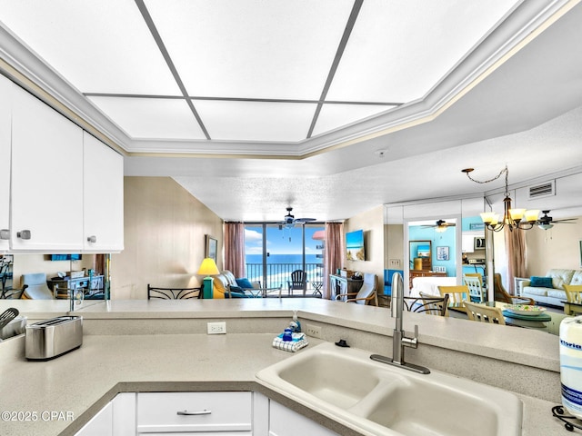 6505 Thomas Dr Unit 1009B, Panama City Beach, FL 32408 - kitchen featuring a sink, a ceiling fan, open floor plan, white cabinetry, and light countertops