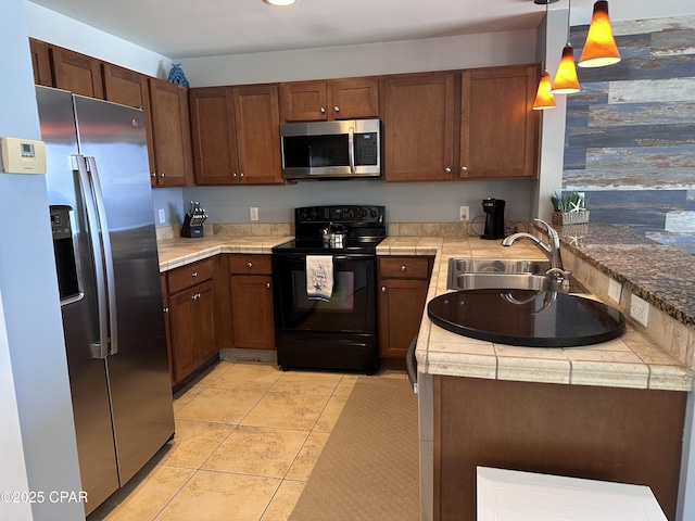 15100 Front Beach Rd Unit 1416, Panama City Beach, FL 32413 - kitchen with appliances with stainless steel finishes, a sink, hanging light fixtures, light tile patterned floors, and tile countertops