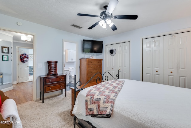 1402 New Hampshire Ave, Lynn Haven, FL 32444 - bedroom with two closets, light carpet, ceiling fan, baseboards, and ensuite bathroom