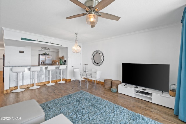 14701 Front Beach Rd Unit 1735, Panama City Beach, FL 32413 - living room featuring ornamental molding, wood finished floors, a chandelier, ceiling fan, and baseboards
