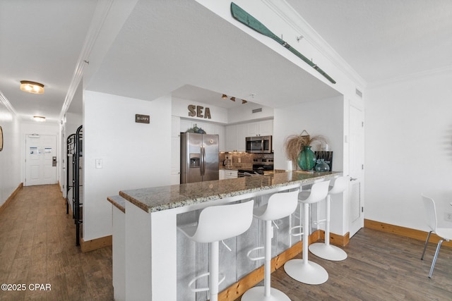 14701 Front Beach Rd Unit 1735, Panama City Beach, FL 32413 - kitchen featuring stainless steel appliances, baseboards, wood finished floors, white cabinetry, and a peninsula
