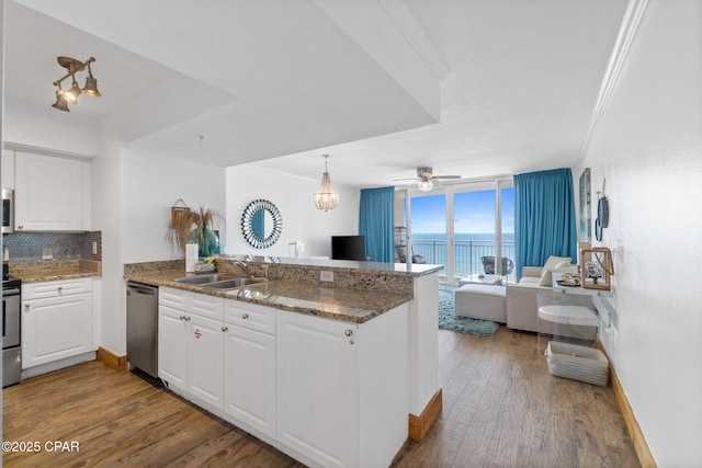 14701 Front Beach Rd Unit 1735, Panama City Beach, FL 32413 - kitchen featuring stainless steel appliances, a peninsula, crown molding, white cabinetry, and decorative backsplash