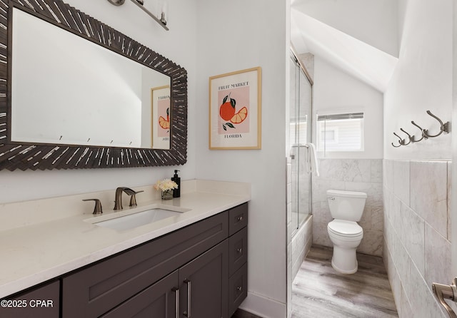 98 Shirah St, Destin, FL 32541 - full bathroom with vanity, wood finished floors, tile walls, combined bath / shower with glass door, and vaulted ceiling