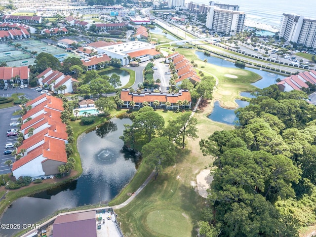 aerial view of property and surrounding area featuring a nearby body of water and a golf course