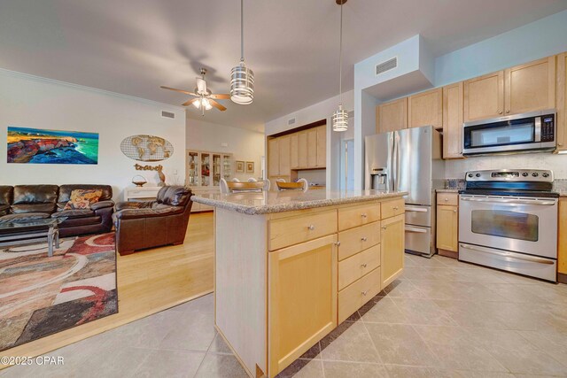 8700 Front Beach Rd Unit 7101, Panama City Beach, FL 32407 - kitchen featuring stainless steel appliances, light brown cabinetry, open floor plan, a ceiling fan, and light tile patterned flooring