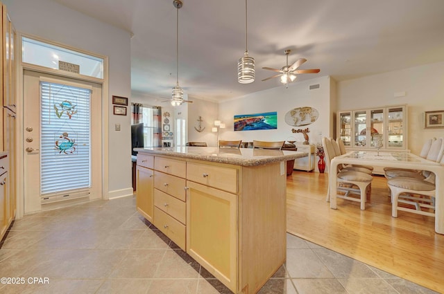 8700 Front Beach Rd Unit 7101, Panama City Beach, FL 32407 - kitchen featuring a ceiling fan, open floor plan, a kitchen island, light brown cabinetry, and light tile patterned flooring