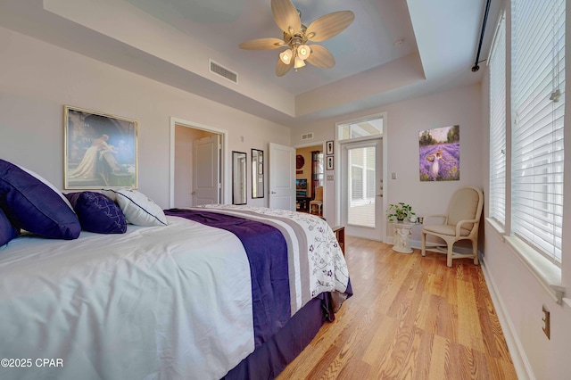8700 Front Beach Rd Unit 7101, Panama City Beach, FL 32407 - bedroom featuring light wood finished floors, a tray ceiling, baseboards, and a ceiling fan