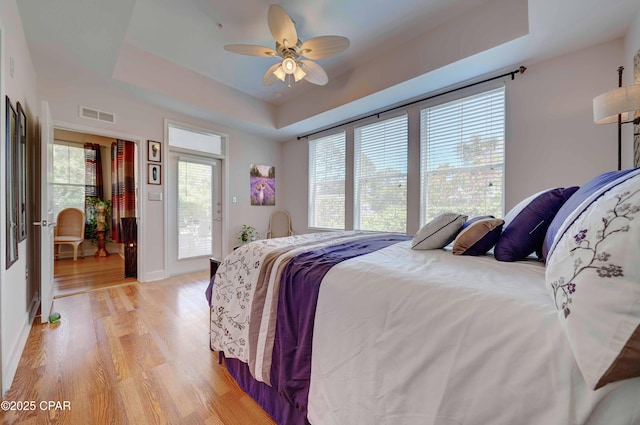 8700 Front Beach Rd Unit 7101, Panama City Beach, FL 32407 - bedroom featuring a raised ceiling, light wood-style flooring, access to exterior, baseboards, and a ceiling fan