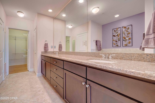 8700 Front Beach Rd Unit 7101, Panama City Beach, FL 32407 - full bathroom with double vanity, a walk in closet, tile patterned flooring, and baseboards