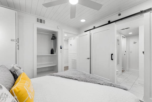 9850 S Thomas Dr Unit 1112E, Panama City Beach, FL 32408 - bedroom with a barn door, light marble finish flooring, ensuite bathroom, recessed lighting, and wooden ceiling