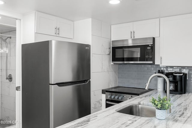 9850 S Thomas Dr Unit 1112E, Panama City Beach, FL 32408 - kitchen featuring stainless steel appliances, a sink, light stone countertops, white cabinets, and recessed lighting