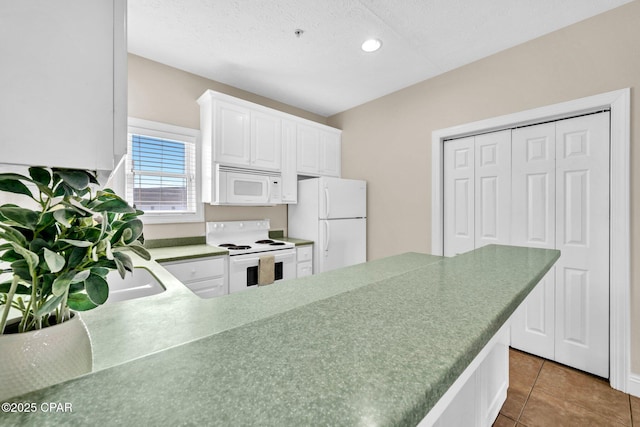 216 Bonita Cir Unit C, Panama City, FL 32408 - kitchen with white appliances, white cabinets, recessed lighting, tile patterned floors, and a textured ceiling