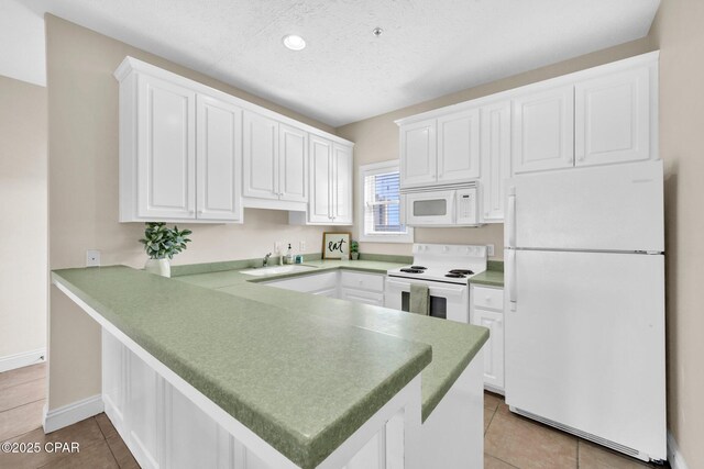 216 Bonita Cir Unit C, Panama City, FL 32408 - kitchen featuring white appliances, a peninsula, a sink, white cabinets, and a textured ceiling