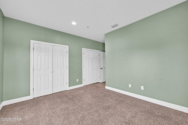 216 Bonita Cir Unit C, Panama City, FL 32408 - unfurnished bedroom with two closets, carpet flooring, baseboards, and recessed lighting
