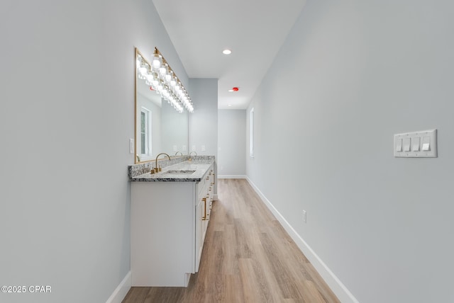 12809 Merial Green Way, Southport, FL 32409 - hallway with a sink, light wood-type flooring, baseboards, and recessed lighting
