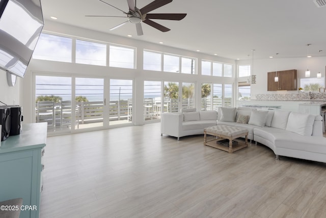 13826 Front Beach Rd, Panama City Beach, FL 32413 - living room featuring a ceiling fan, light wood-style flooring, recessed lighting, and a towering ceiling