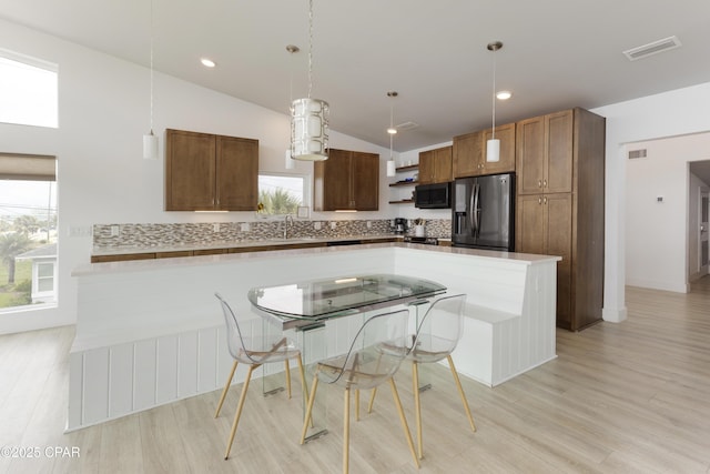 13826 Front Beach Rd, Panama City Beach, FL 32413 - kitchen with stainless steel refrigerator with ice dispenser, black microwave, lofted ceiling, light wood finished floors, and a center island