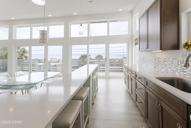 13826 Front Beach Rd, Panama City Beach, FL 32413 - kitchen featuring a sink, light countertops, recessed lighting, decorative light fixtures, and a breakfast bar