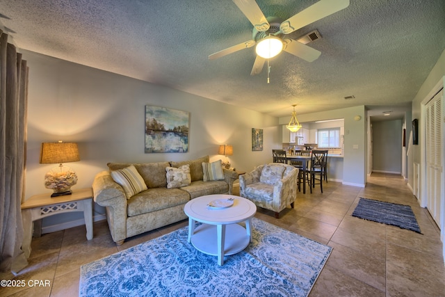 17620 Front Beach Rd Unit Y3, Panama City Beach, FL 32413 - tiled living area featuring a textured ceiling, ceiling fan, and baseboards