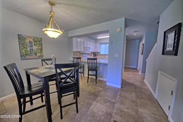17620 Front Beach Rd Unit Y3, Panama City Beach, FL 32413 - dining area featuring a textured ceiling, baseboards, and light tile patterned floors
