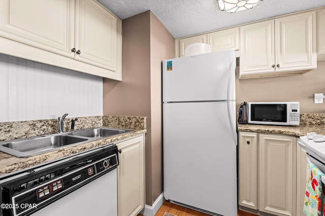 23223 Front Beach Rd Unit A509, Panama City Beach, FL 32413 - kitchen featuring white appliances, a sink, light wood-type flooring, cream cabinetry, and a textured ceiling