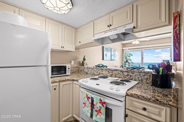 23223 Front Beach Rd Unit A509, Panama City Beach, FL 32413 - kitchen with white appliances, under cabinet range hood, cream cabinets, a textured ceiling, and light stone countertops