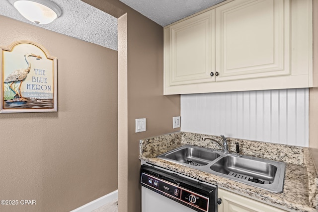 23223 Front Beach Rd Unit A509, Panama City Beach, FL 32413 - kitchen with white dishwasher, a sink, light stone counters, baseboards, and a textured ceiling