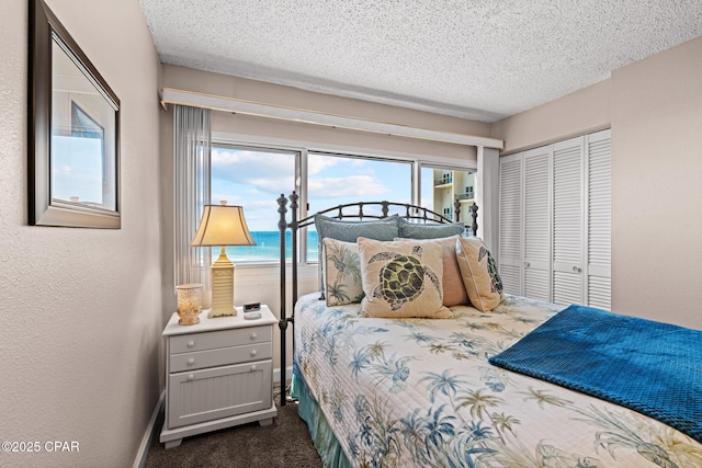 23223 Front Beach Rd Unit A509, Panama City Beach, FL 32413 - bedroom featuring dark carpet, a closet, a textured ceiling, and access to exterior