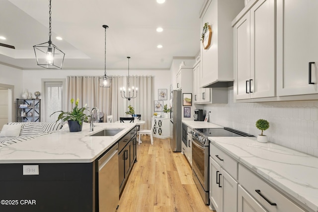 3928 Sandpine Way, Panama City, FL 32404 - kitchen with stainless steel appliances, a sink, decorative backsplash, light wood-style floors, and an island with sink
