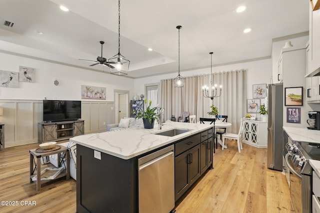 3928 Sandpine Way, Panama City, FL 32404 - kitchen featuring appliances with stainless steel finishes, a sink, a ceiling fan, a center island with sink, and light wood finished floors