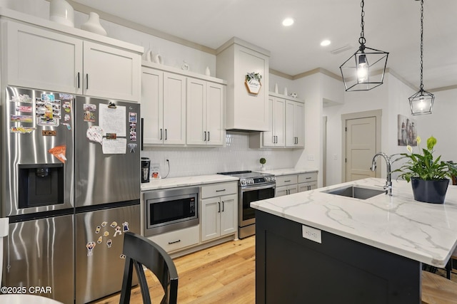 3928 Sandpine Way, Panama City, FL 32404 - kitchen featuring appliances with stainless steel finishes, a sink, decorative backsplash, pendant lighting, and light wood finished floors