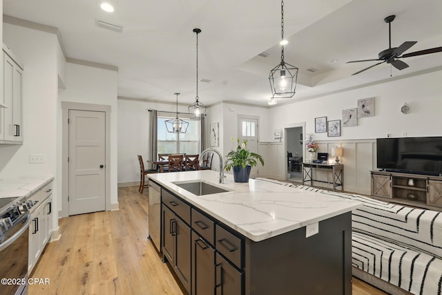 3928 Sandpine Way, Panama City, FL 32404 - kitchen featuring a sink, appliances with stainless steel finishes, ceiling fan, light wood finished floors, and a center island with sink