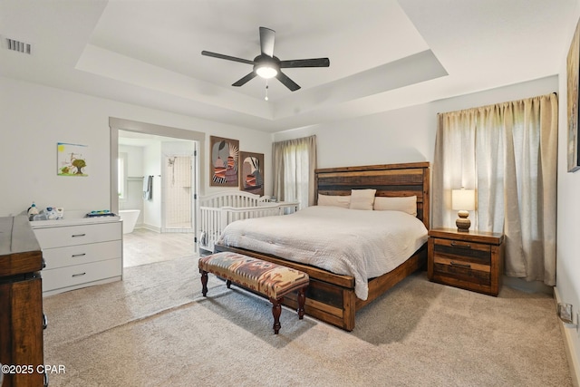 3928 Sandpine Way, Panama City, FL 32404 - bedroom featuring a tray ceiling, carpet flooring, ensuite bath, a ceiling fan, and multiple windows