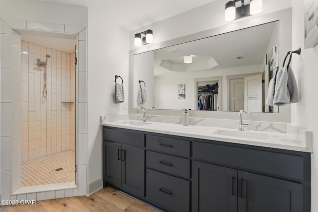 3928 Sandpine Way, Panama City, FL 32404 - bathroom featuring a shower stall, double vanity, wood finished floors, and a walk in closet